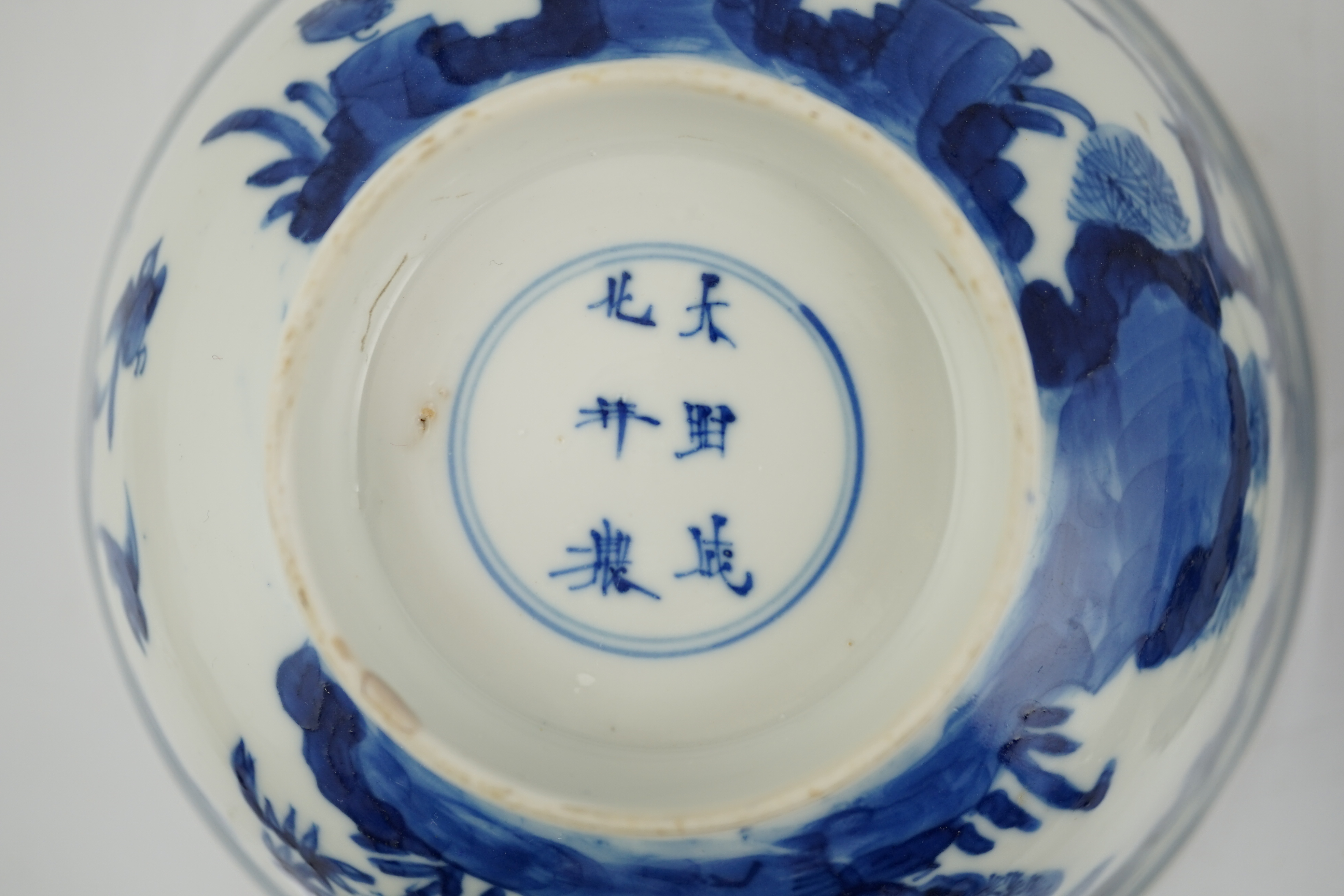 A near pair of Chinese blue and white ‘birds’ bowls, Kangxi period, one bowl restored